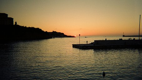 A golden sunset over a quiet harbour